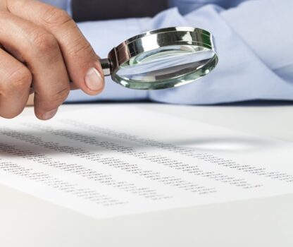 Businesswoman Holding Magnifying Glass, close-up view