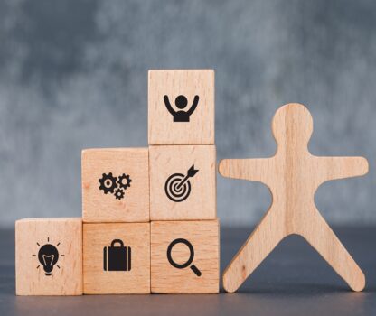 Conceptual of success and target. with wooden human and blocks on dark color background side view. horizontal image